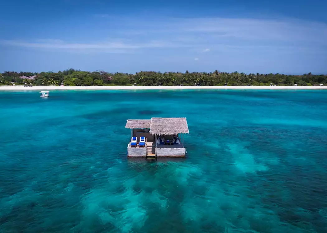 Floating Kawayan Bar at Amanpulo, Philippines, surrounded by turquoise waters and offering an exclusive private lounge experience.
