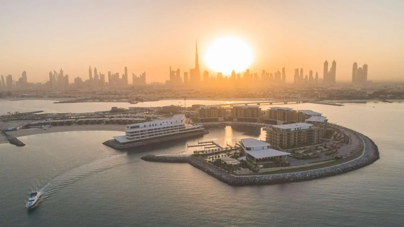 Panoramic aerial view of The Bulgari Resort Dubai with the city skyline at sunset.
