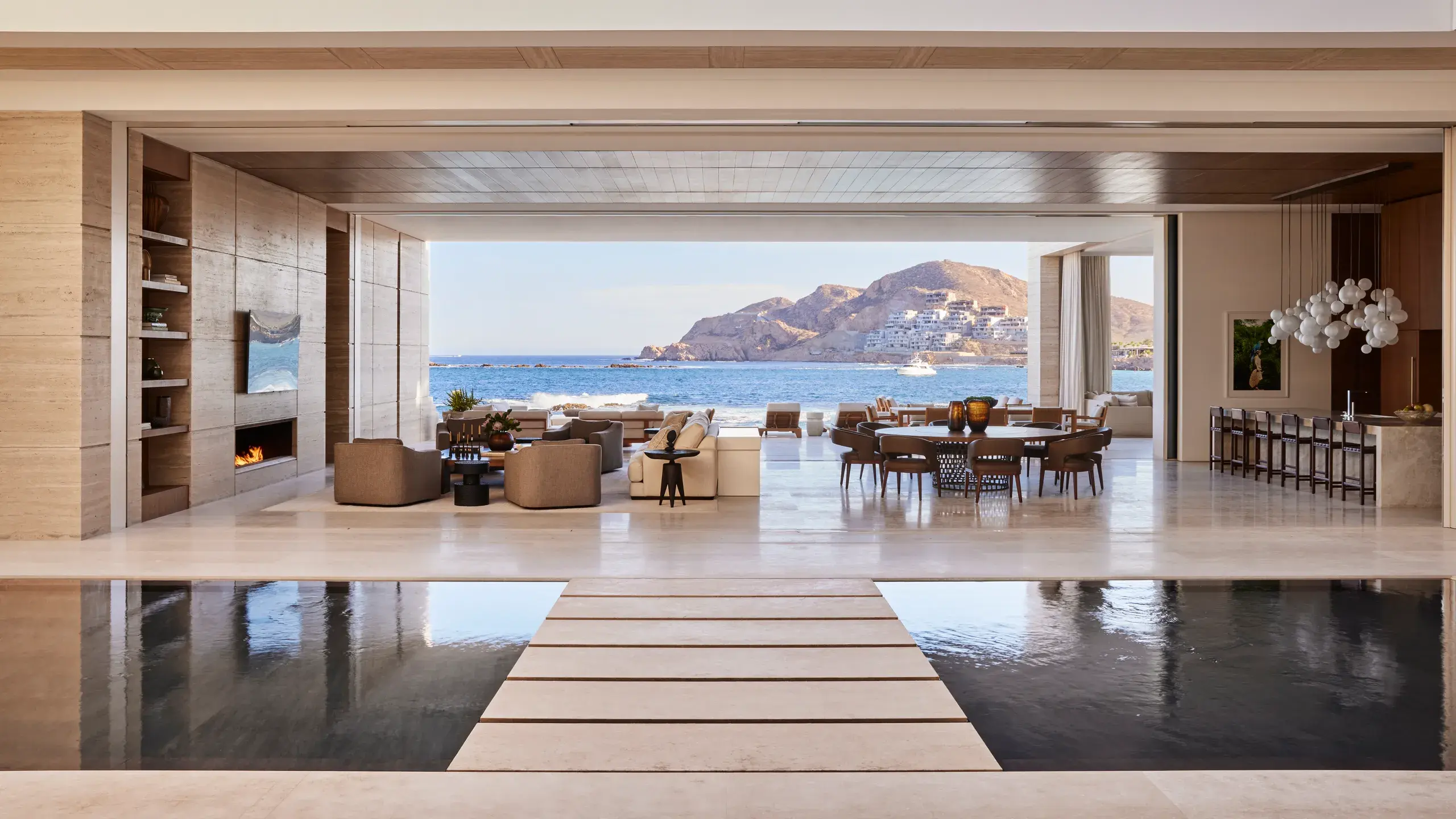 Luxury coastal villa with open living room, ocean view terrace, and contemporary dining area in Cabo.