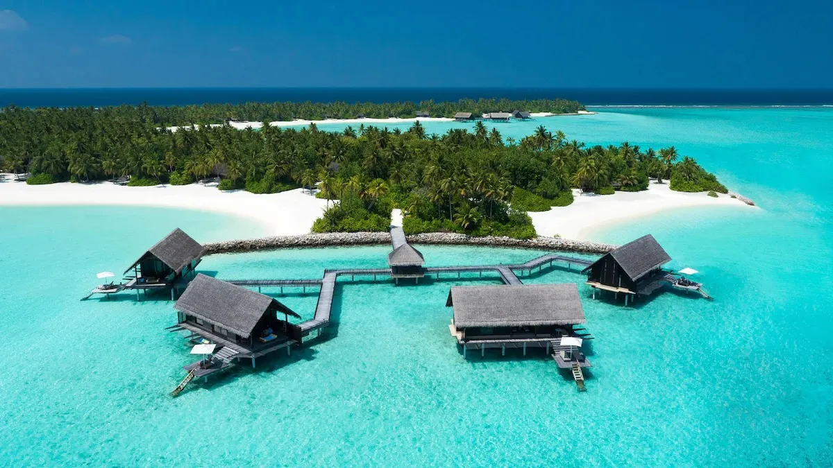 Overwater villas surrounded by turquoise lagoon at One&Only Reethi Rah in the Maldives.