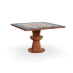 Vedrà dining table by Mediterrazza in iroko wood, featuring a sculptural base and a ceramic top with a radiant sun motif.