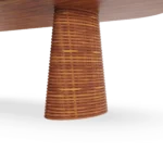 Close-up of the Altea dining table's ribbed iroko base, showing its sculptural texture and the smooth travertine top.
