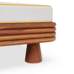 Macro view of the Jondal sunbed by Mediterrazza, highlighting the contemporary sculptural conical feet and the natural grain of the iroko wood.