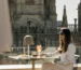 Luxury rooftop terrace with a woman enjoying a cocktail overlooking Gothic cathedral architecture: outdoor furniture inspiration