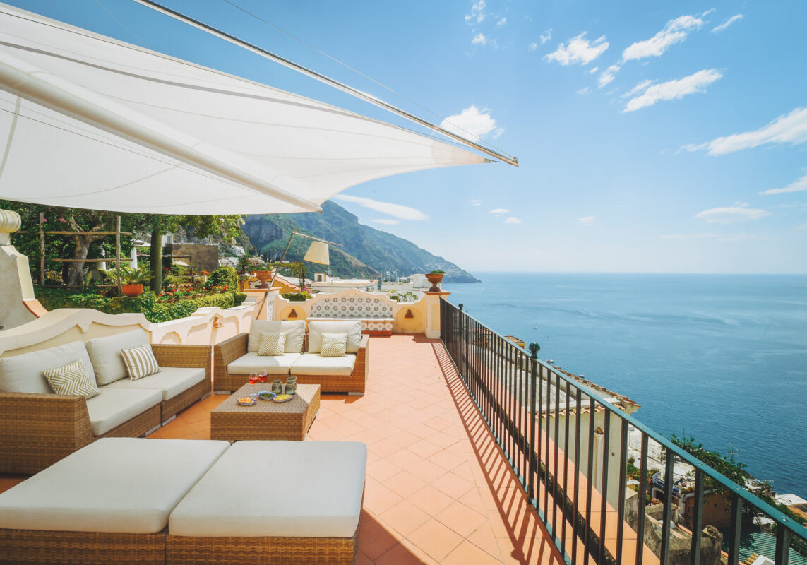 Luxury Amalfi Coast terrace with contemporary outdoor sofas, terracotta flooring, and panoramic views over the Mediterranean Sea