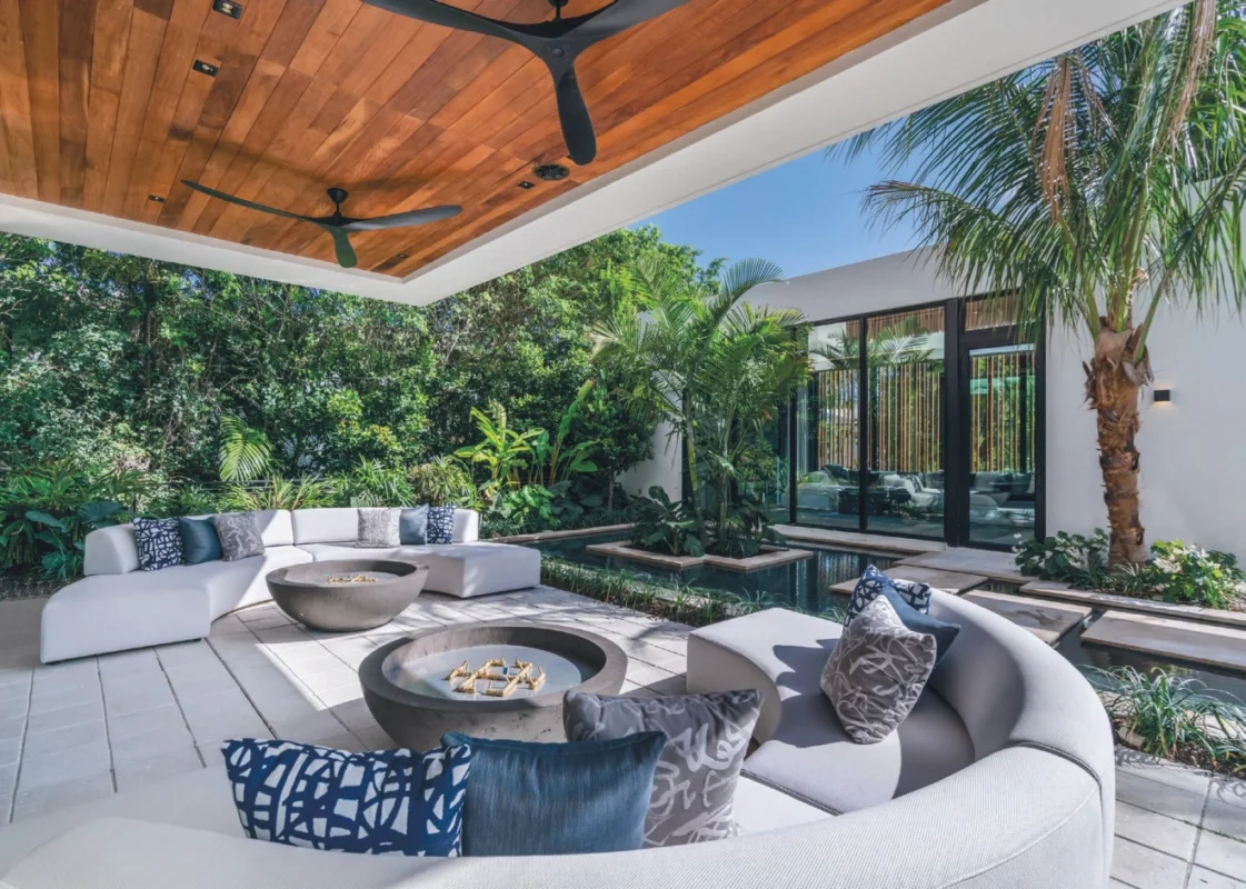 Elegant outdoor lounge in a Miami high-end villa with sculptural seating, tropical landscaping, and modern architectural details