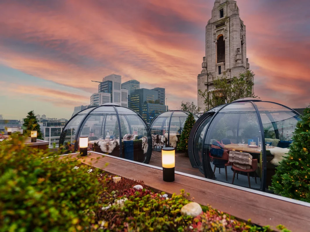 Winter rooftop terrace in London with transparent heated dining domes, showcasing innovative design for all-season outdoor living.
