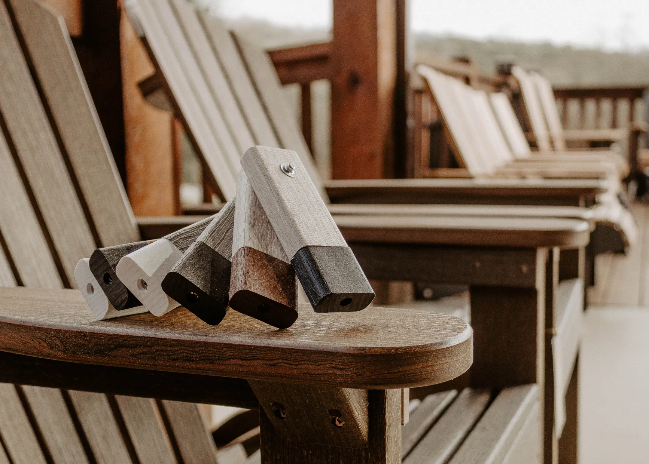 Close-up of weathered outdoor wooden chairs with durable composite accents, highlighting high-performance materials used in luxury outdoor furniture.