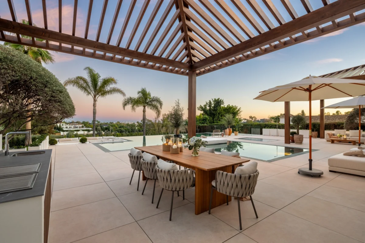 Luxury Mediterranean villa showcasing refined outdoor living, with contemporary outdoor furniture, expansive terraces, pools, and landscaped gardens designed for elegant villa life in Marbella.