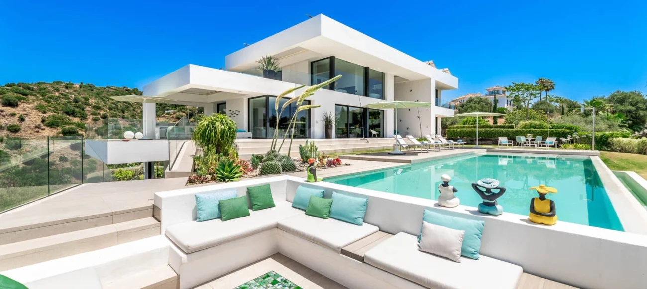 Luxury Mediterranean villa showcasing refined outdoor living, with contemporary outdoor furniture, expansive terraces, pools, and landscaped gardens designed for elegant villa life in Marbella.