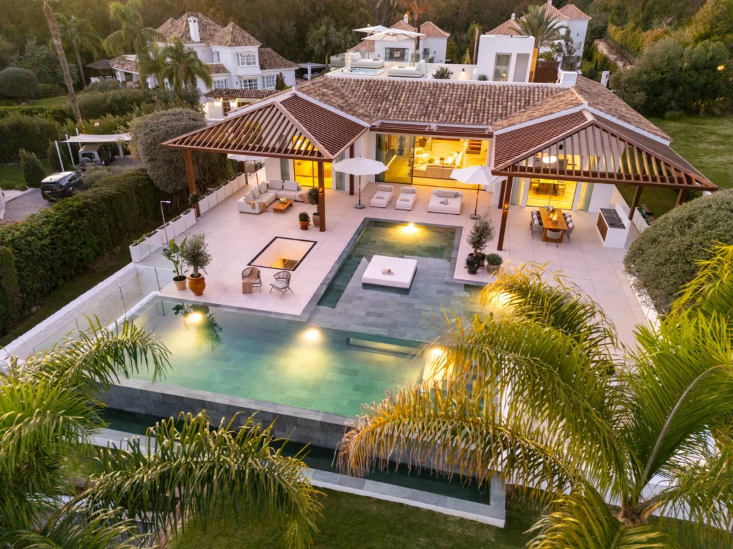 Luxury Mediterranean villa showcasing refined outdoor living, with contemporary outdoor furniture, expansive terraces, pools, and landscaped gardens designed for elegant villa life in Marbella.