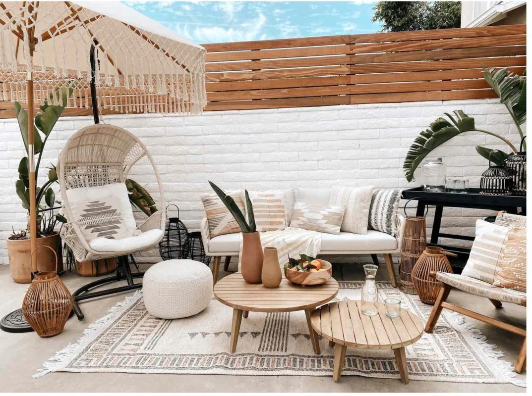 Luxury outdoor seating with woven sofas and neutral cushions in a serene indoor-outdoor living space