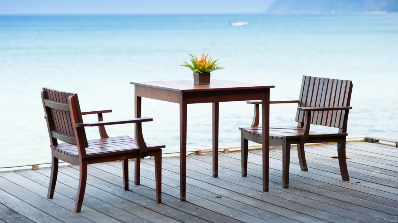 Luxury coastal second home with seamless indoor–outdoor living, featuring neutral-toned interiors, floor-to-ceiling ocean views, teak outdoor furniture, and refined high-end vacation home design details tailored for elegant intermittent living.