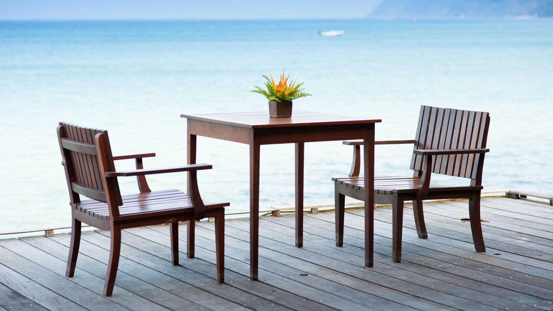 Luxury coastal second home with seamless indoor–outdoor living, featuring neutral-toned interiors, floor-to-ceiling ocean views, teak outdoor furniture, and refined high-end vacation home design details tailored for elegant intermittent living.