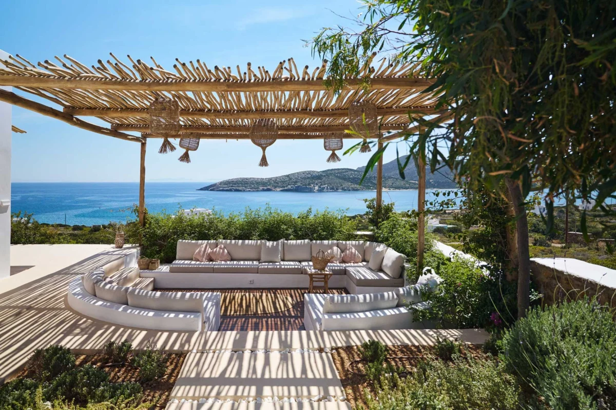 Luxury summer home terrace featuring architectural pergolas and sunshades with elegant shaded outdoor seating, blending Mediterranean-inspired design, contemporary rooftop solutions, and integrated greenery for refined climate-responsive outdoor living.