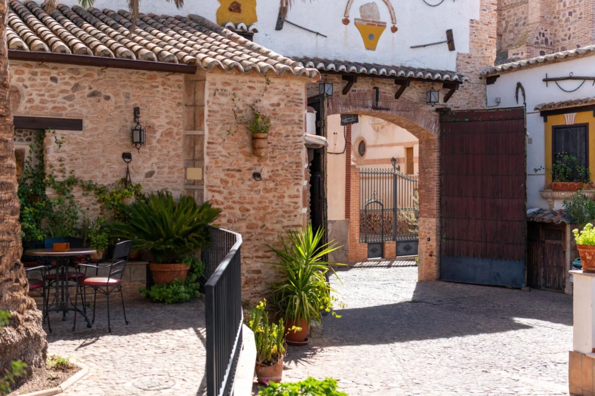 Traditional Andalusian courtyard in Marbella featuring stone walls, terracotta roof tiles, and intimate outdoor seating reflecting Mediterranean lifestyle.