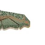 Close-up of the Matera parasol showing the green ikat-patterned fabric, decorative fringe trim, and handcrafted wooden ribs underneath.