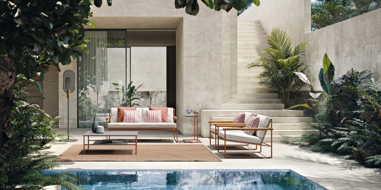 Contemporary outdoor seating set beside a modern pool, combining modular sofas and armchairs within a refined architectural courtyard.