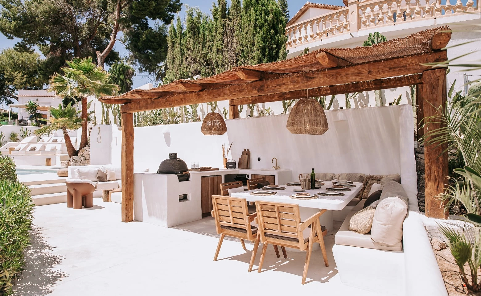 Luxury villas in Spain along the Costa del Sol featuring architecturally integrated outdoor kitchens, panoramic Mediterranean terraces, premium stone and stainless steel finishes, resort-style pergolas, and elegant alfresco entertaining spaces at sunset and night.