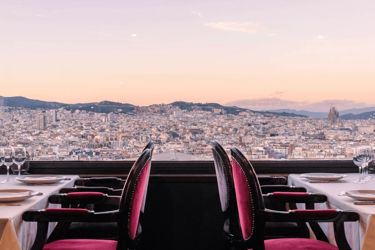 Panoramic view over Barcelona from an elegant restaurant terrace, highlighting refined open-air dining with city skyline and Mediterranean atmosphere.