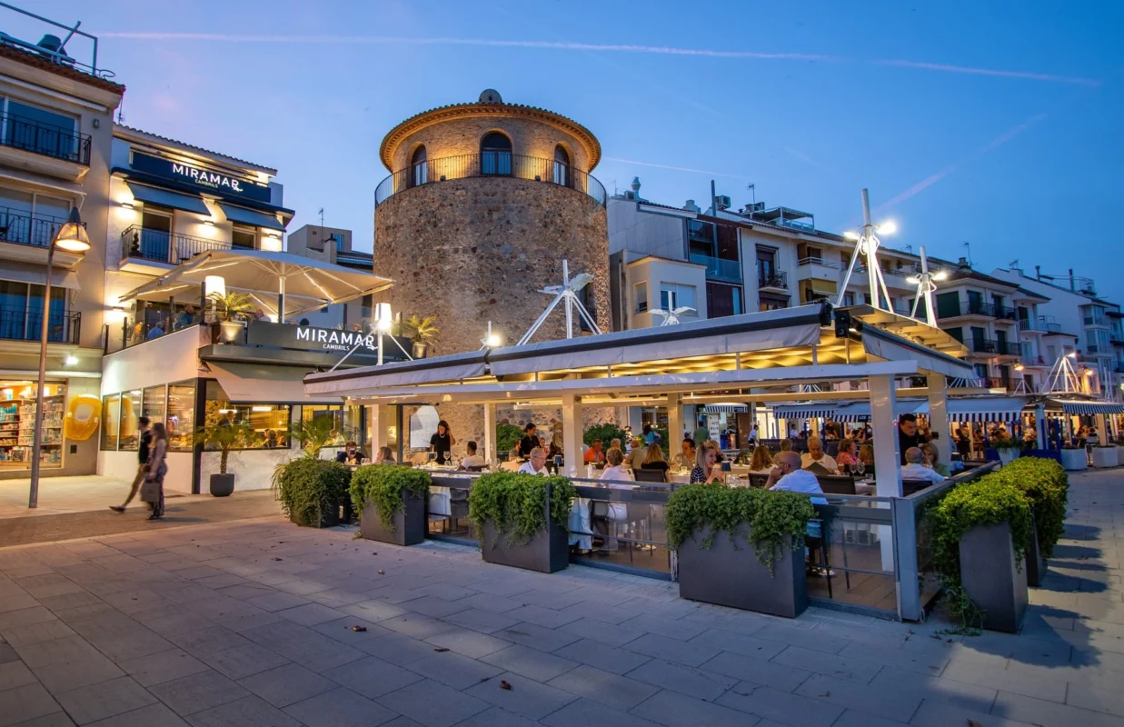 Miramar Restaurant outdoor terrace in Barcelona at dusk, blending historic architecture, contemporary design, and vibrant open-air dining by the waterfront.