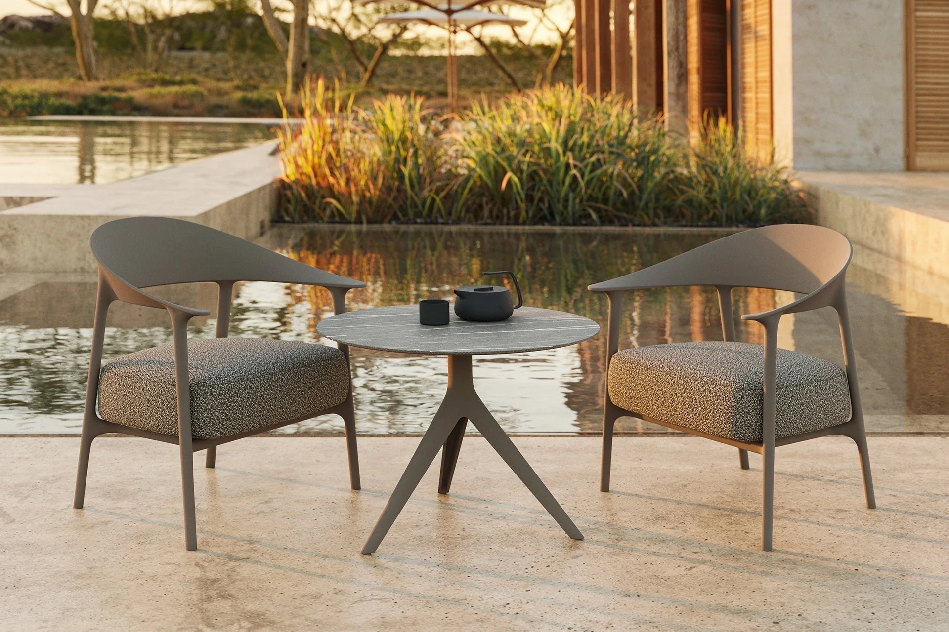 Sculptural contemporary outdoor furniture with soft, organic forms set within a refined natural landscape, expressing luxury outdoor living through fluid design, tactile materials, and seamless integration with architecture and greenery