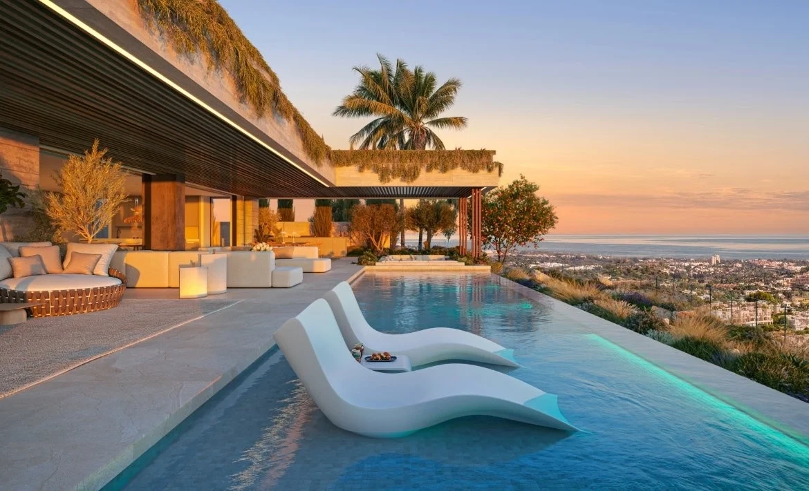 Luxurious patio with modern lounge chairs in an infinity pool overlooking a cityscape. Palm trees and soft sunset create a serene, elegant ambiance, commonly found in marbella residences.