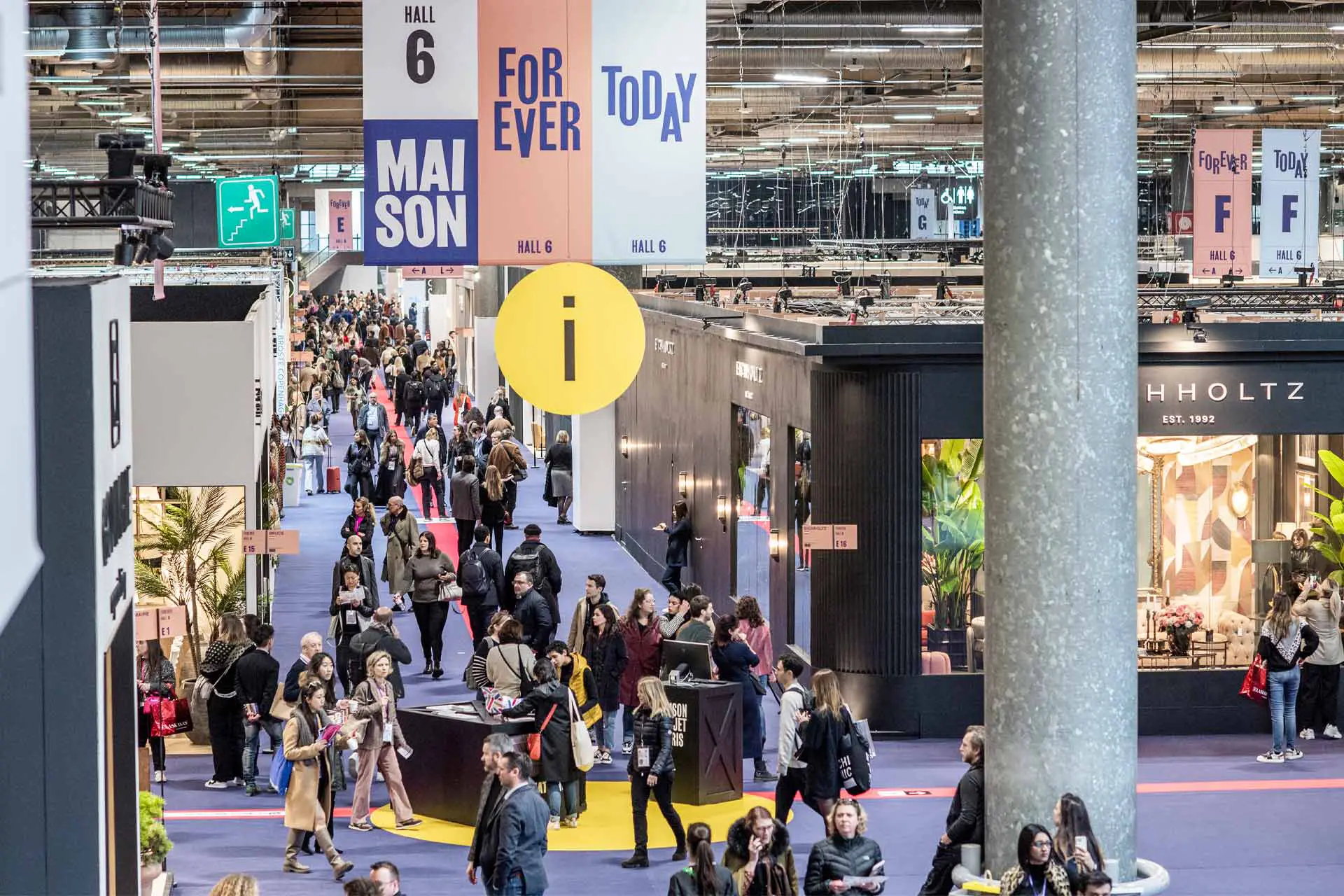 Busy Maison&Objet trade show hall with people walking among booths. Large signs hang above, reading "Forever Today" and "Maison." Vibrant, bustling atmosphere.