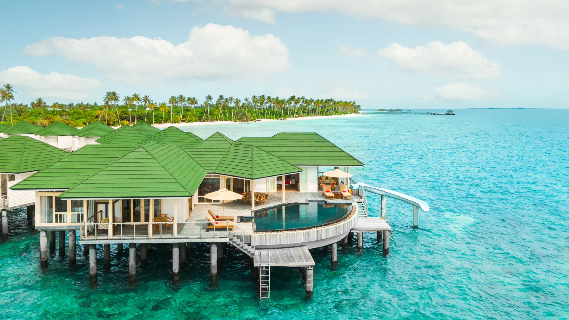Maldives Island Resorts with luxury overwater bungalow architecture and outdoor lounging terraces above turquoise lagoons