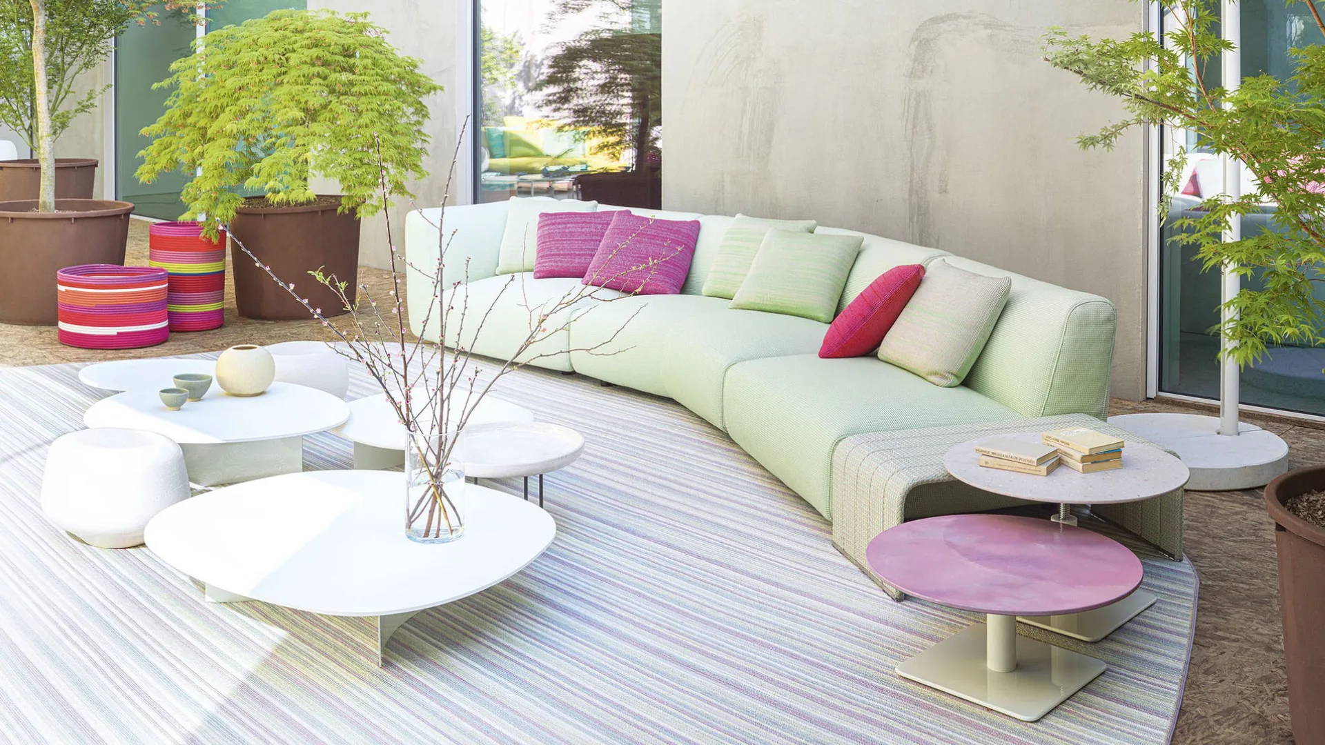 Colorful Paola Lenti luxury outdoor furniture on a Mediterranean terrace showcasing vibrant textiles, woven textures, and contemporary outdoor design.