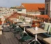 Luxury rooftop terraces in Lisbon homes featuring wind resistant outdoor furniture, elegant rooftop furniture layout, pergolas, and Mediterranean plants overlooking the River.