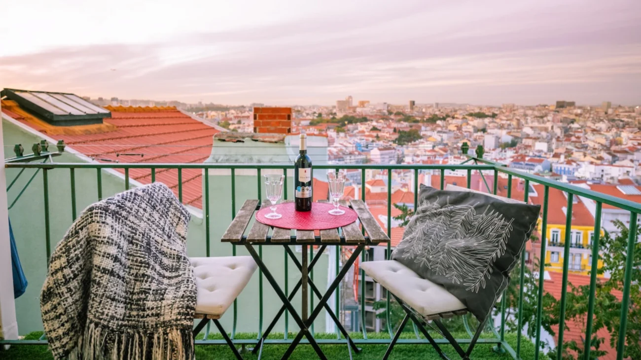 Luxury rooftop terraces in Lisbon homes featuring wind resistant outdoor furniture, elegant rooftop furniture layout, pergolas, and Mediterranean plants overlooking the River.