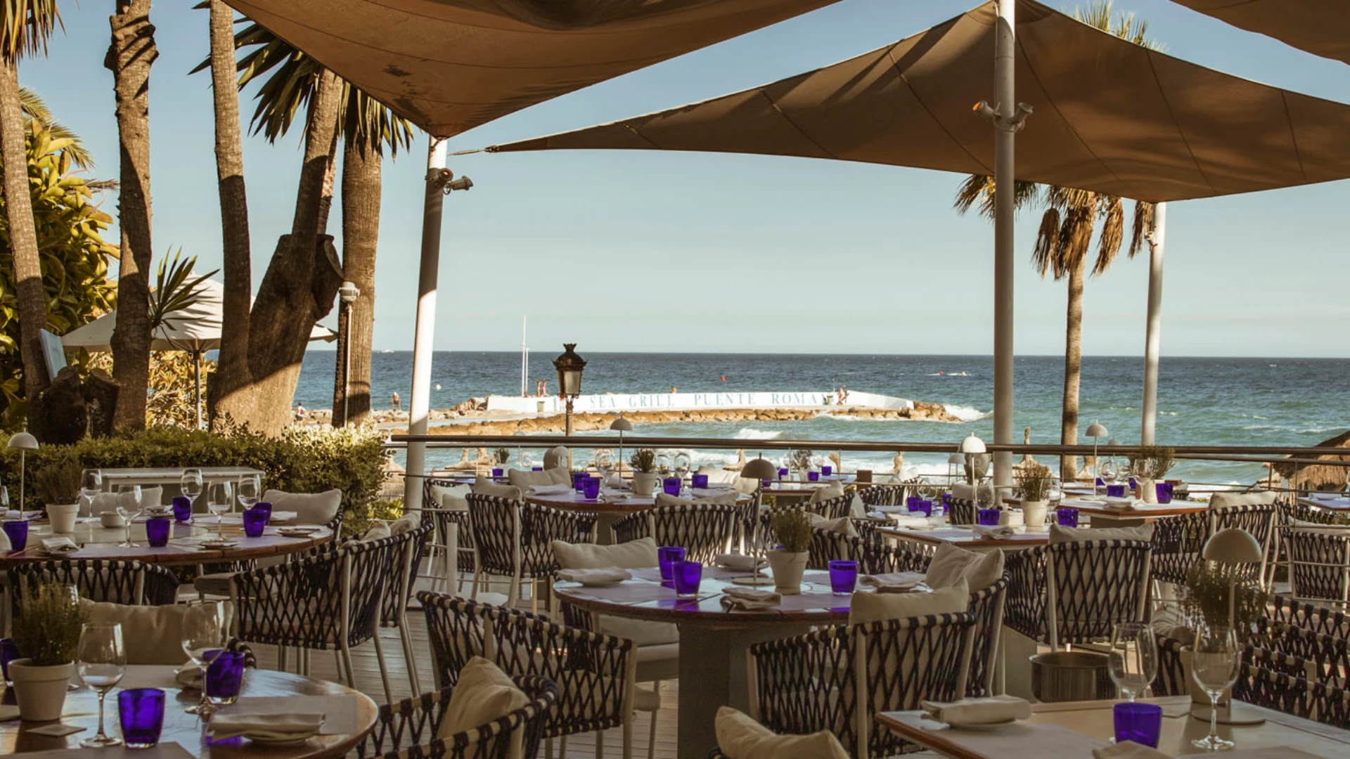 Luxury outdoor dining terrace at a Marbella beachfront restaurant showcasing elegant Mediterranean design, sea views, and refined alfresco atmosphere.