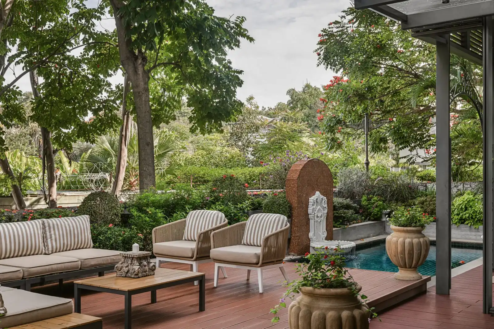 Outdoor luxury living design featuring a contemporary villa terrace with modern architecture, natural materials, lounge seating, and seamless integration between interior and exterior spaces.