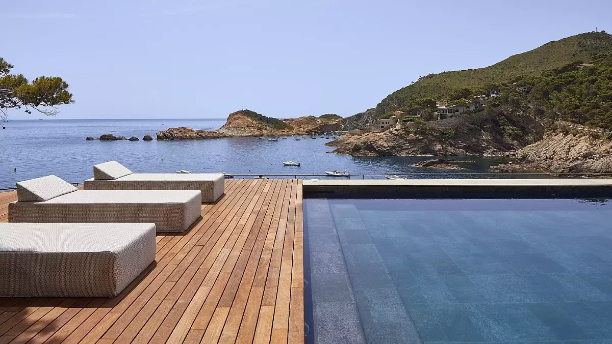 Mediterranean luxury architecture showcasing modern villa outdoor living with infinity pool, stone materials, and seamless integration with natural coastal landscape
