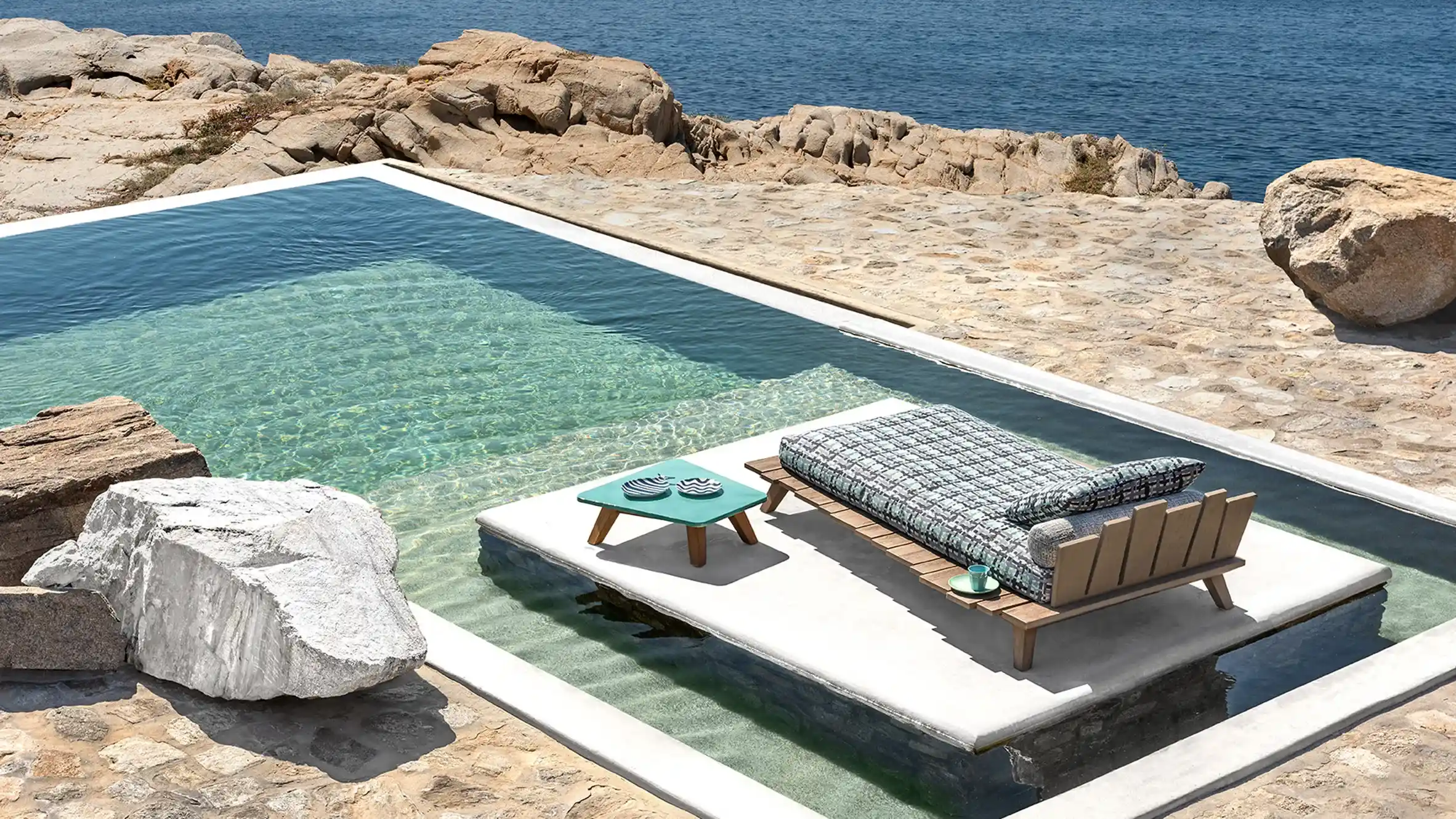 Paola Navone in outdoor Luxury Architecture, with view to a pool and ocean