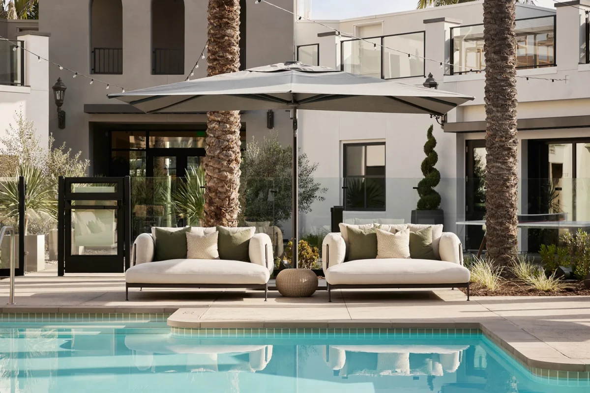 Mediterranean design fairs showcasing luxury outdoor lounge spaces with natural textures, contemporary furniture, and warm architectural lighting.
