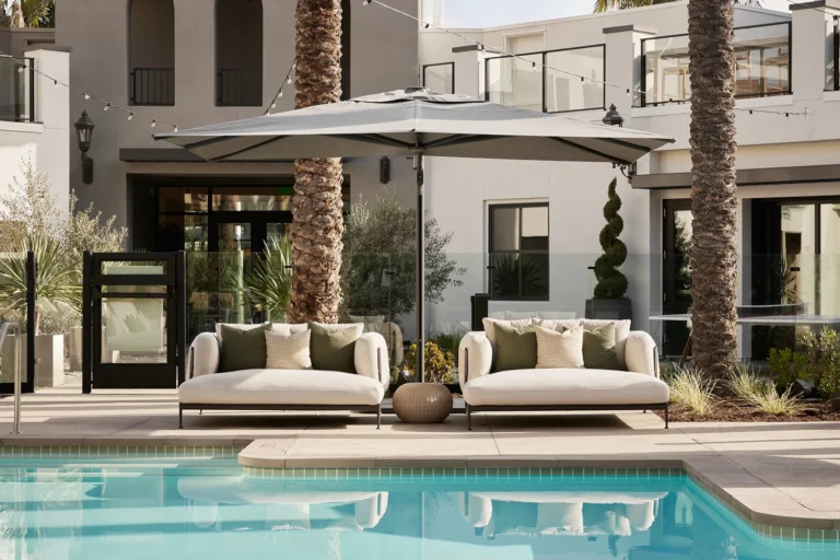 Mediterranean design fairs showcasing luxury outdoor lounge spaces with natural textures, contemporary furniture, and warm architectural lighting.
