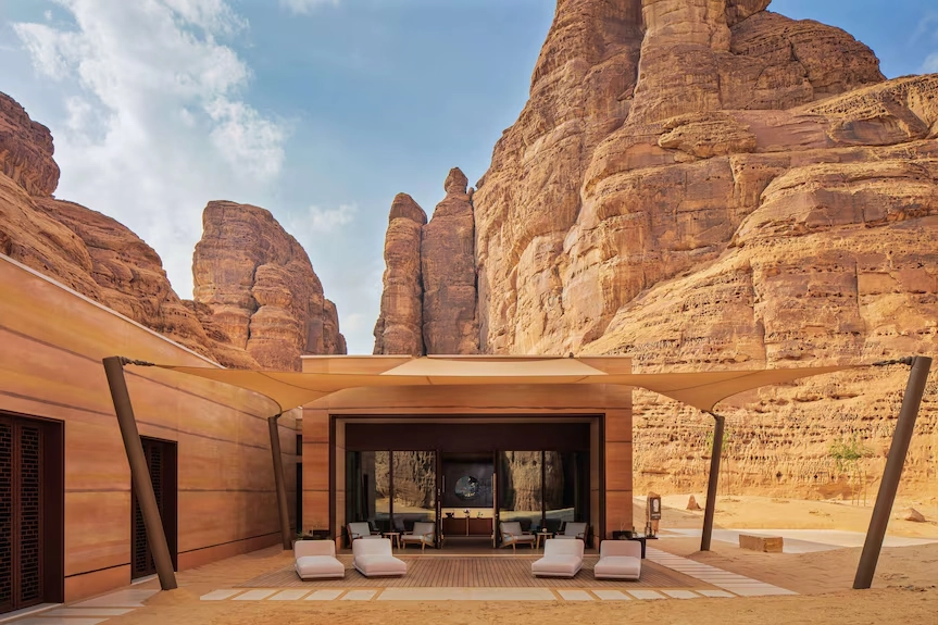 Banyan Tree AlUla resort, with a sleek wooden facade, white lounge chairs, and pergola, that make this resort one of the best 5 luxury resorts in the Middle East.