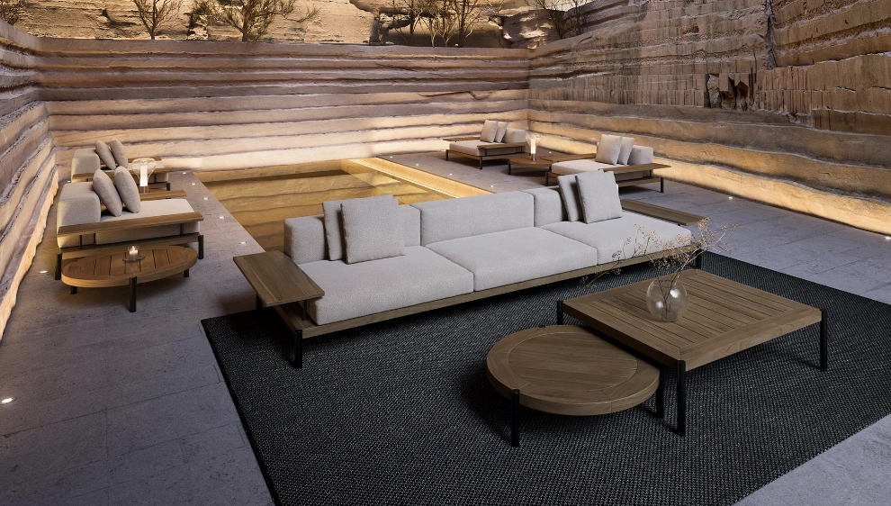 Modern outdoor space with layered rock walls, and the Ladamera Collection furniture set by Francesco Meda. Warm lighting and minimalist decor create a serene, luxurious atmosphere.