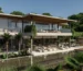 A modern luxury villa by Pedro Peña with large glass windows, a spacious terrace, and lush greenery.
