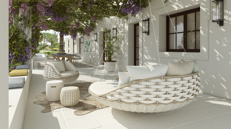 Sunny patio by Pedro Peña with woven hanging chairs, soft cushions, and cozy stools under a pergola with lush greenery and purple flowers, creating a serene ambiance.