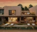 Siz Senses Ibiza, Spain, at sunset with modern architecture, featuring large windows, an outdoor dining area, poolside loungers, and warm ambient lighting.