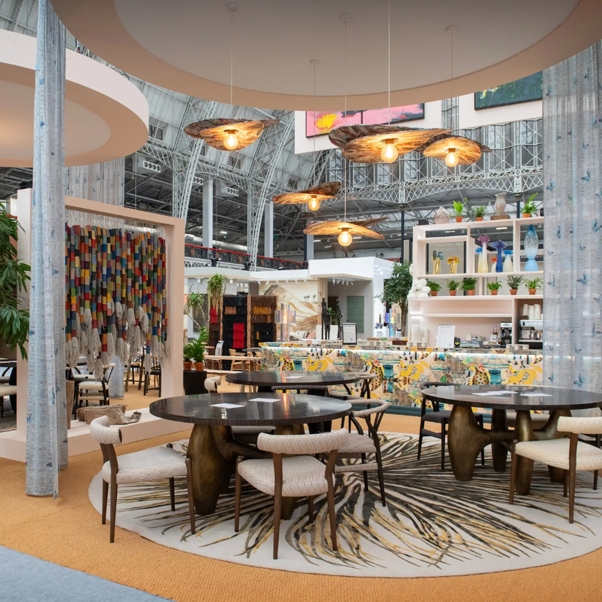 Luxury lounge feature area with sculptural pendant lighting and contemporary dining sets at Decorex.