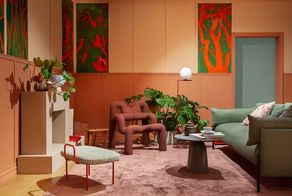 Curated interior living room exhibition installation featuring terracotta walls and sculptural seating at Oslo Design Fair.